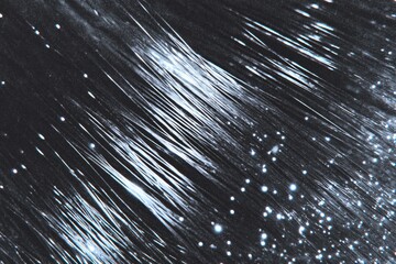 A close-up view of shining strands with a starry background, creating a blend of light and texture.