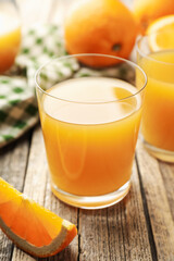 Fresh orange juice and fruits on wooden table, closeup