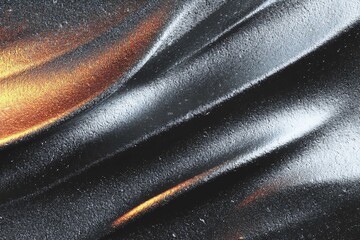 A close-up of shiny, textured fabric with waves of black and hints of gold.