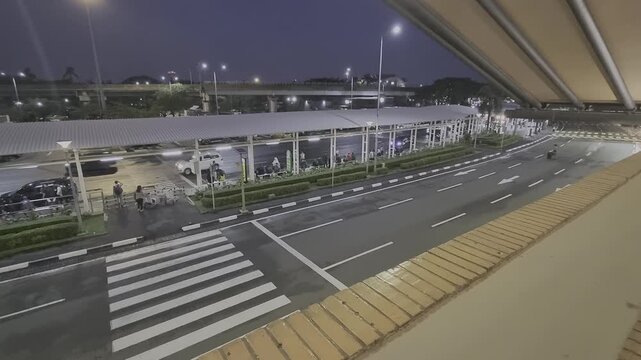 Airport pickup and drop off activity in front of SoekarnoHatta Terminal One, vehicles and passengers moving through busy transportation area at international airport.