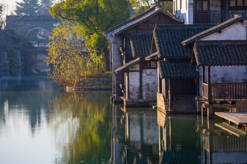 Sunrise view of the Chinese-style ancient architectural complex by the ancient bridge and flowing water in Yanguan Ancient City, Jiaxing, China