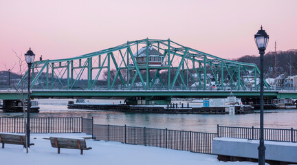 Naklejka premium Grand Avenue Swing Bridge with its control house over the Quinnipiac River in Fair Haven, New Haven County, Connecticut, USA at sunset with a pink sky
