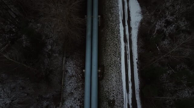 High altitude perspective displaying pipeline amid snowcovered forest and water reflections