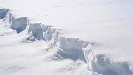 Snow drift border with a clean snowbank edge in a winter landscape during daytime