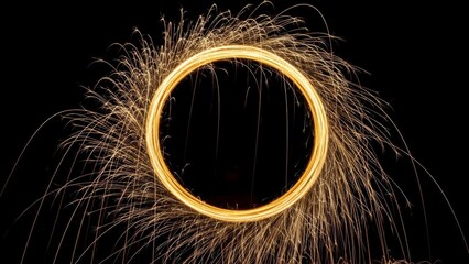 Golden light trail circle with sparks on black background.