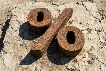 Corroded metal percentage symbol casting heavy shadow symbolizing financial crisis