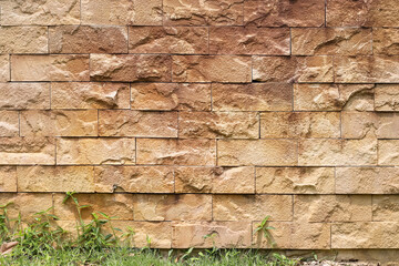 Sandstone brown fence with green grass growing