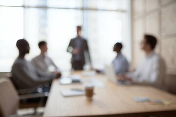Engaged professionals in a blurred strategic business meeting, fostering collaborative discussion and teamwork for corporate planning within a modern office setting
