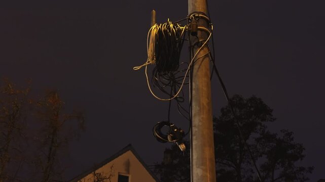 Utility pole with tangled wires and visible splicing suggests ongoing electrical maintenance