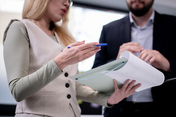 Professionals reviewing documents during a workplace discussion while exchanging expertise
