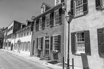 Sunlit historic homes line a charming Charleston street.