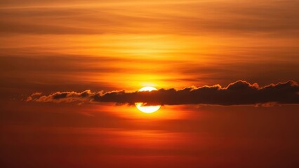 Fototapeta premium Fiery sunset illuminates layered clouds with the sun peeking through