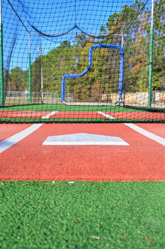 A view behind home plate in a baseball batting cage