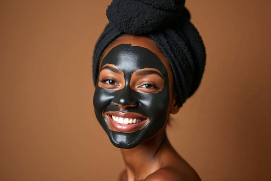 Smiling Young Black Woman with Charcoal Face Mask and Black Head Towel - Powered by Adobe