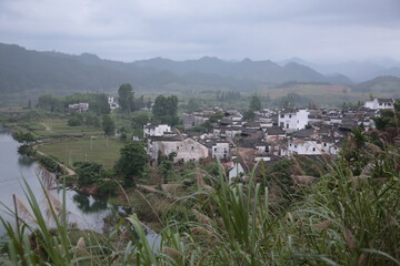 View of Ancient village and its Chinese Huizhou Architecture style residential houses with mountains and forest in Wuyuan county, Jiangxi province, China. © CYSUN