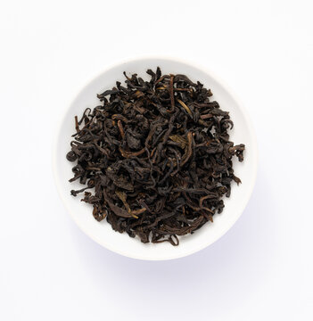 Black tea leaves. Tea sample in white dish. Black tea sample. Tea leaves on white background.	