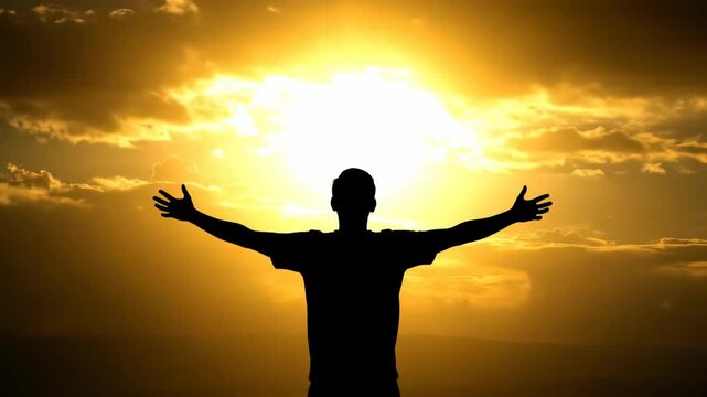 Silhouette of a man with arms open wide celebrating success against a vibrant golden sunset sky, concept for motivational posters, spiritual awakening and personal development marketing