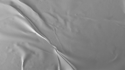 Glued paper texture. Crumpled and wrinkled surface of plain black paper poster background. Wrinkled wet paper