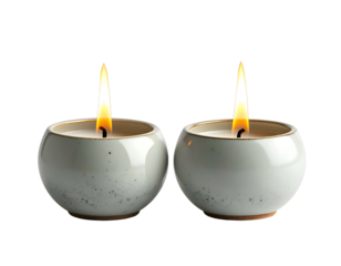 Two softly glowing candles in small ceramic holders
