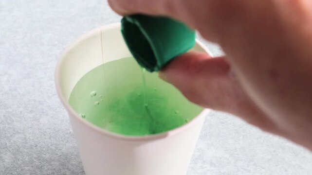 水にうがい薬を入れる人物の動画