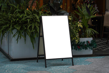 Blank white outdoor advertising stand sandwich board mock up template. Clear street signage board placed by an outdoor dinning area of a restaurant. © Sopear
