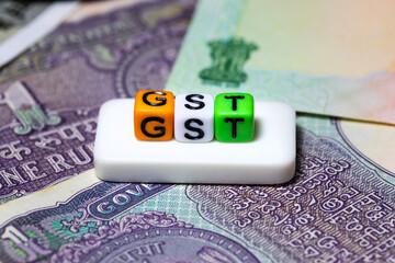 GST (Goods and services tax) in India, concept created with plastic blocks on Indian rupee notes.