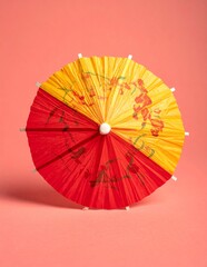 Vibrant Red and Yellow Cocktail Umbrella on a Pink Background.