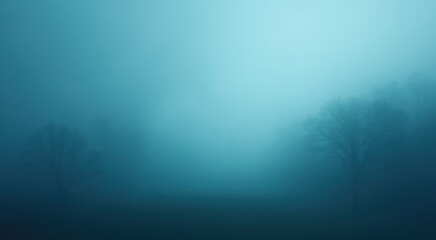 Trees in a foggy field with a blue sky in the background