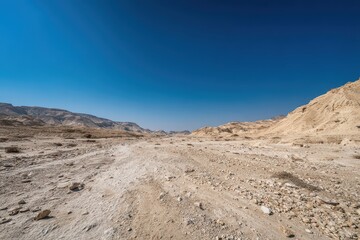 Rocky Desert Landscape Under Clear Blue Sky in Jordan with Hills and Horizon View