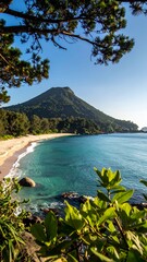 Stunning Coastal Landscape with Pristine Beach and Majestic Mountain.