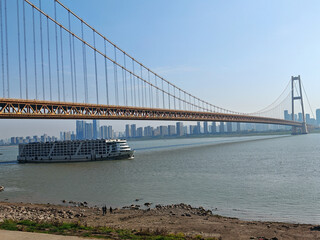 Fototapeta premium Cruise Ship with Yangsigang Suspension Bridge, Wuhan Cityscape