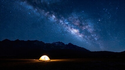 Lit tents on a mountain clearing at night, against a backdrop of a star - studded sky and meteor...