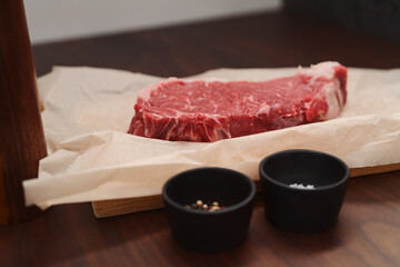 raw new york steak on walnut wood background with copy space