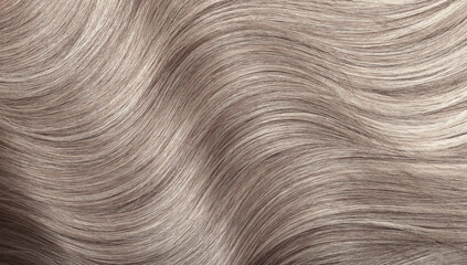 Blond hair close-up as a background. Women's long light brown hair. Beautifully styled wavy shiny...