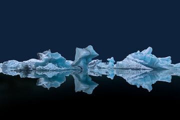 Floating ice blocks on the water surface with reflections against dark blue background in Jokulsarlon Lagoon, Iceland - copy space © Siyue