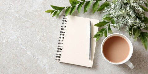 Notebook with pen and tea on neutral surface
