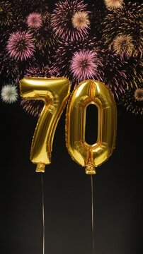 Gold balloon number 70 with fireworks in the background. Festive scene for birthday or anniversary party