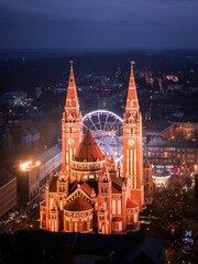 Szeged, Hungary, Giant christmas market at next to Szeged cathedral. Hungarian foods, drinks, presents and gifts. Giant labirintyh and ferris whhel for children