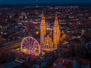 Szeged, Hungary, Giant christmas market at next to Szeged cathedral. Hungarian foods, drinks, presents and gifts. Giant labirintyh and ferris whhel for children