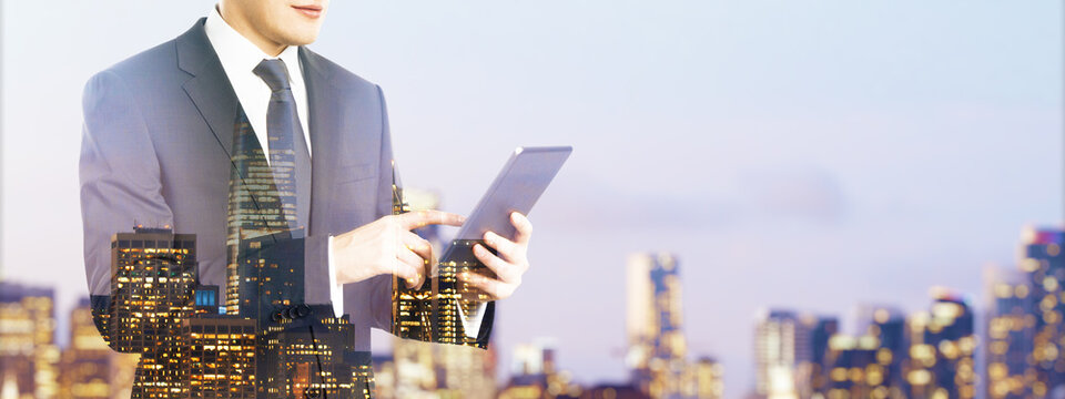 Businessman using tablet with digital device overlay on cityscape background illustrating modern mobile technology and entrepreneurship concept. - Powered by Adobe