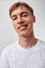 Smiling man in a white t shirt, close up of the face with a casual vibe, bright lighting, and friendly, confident expression for lifestyle and stock photography use