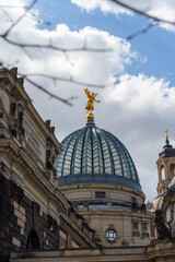 Obraz premium ​Golden angel statue of Pheme on the glass dome of the Academy of Fine Arts in Dresden, Germany.