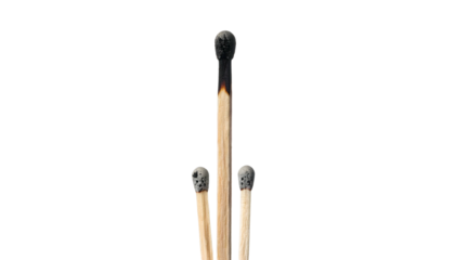 Three wooden matches, one charred, against a black backdrop, showcasing stages of use