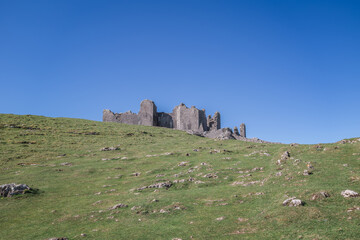 The ruin of Carreg Cennen Castle sited on a high rocky outcrop in Carmarthenshire, Wales on a sunny day