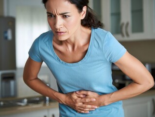 Woman Experiencing Stomach Pain in Kitchen