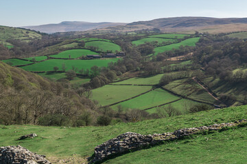 A northward view from Carreg Cennen Castle in Carmarthenshire, Wales, overlooking a rural landscape of rolling green fields