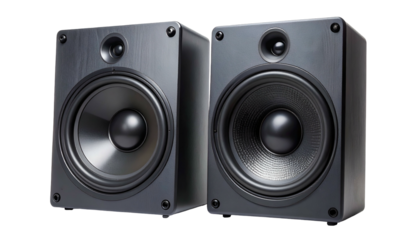 Two boxy, dark speakers, likely part of a sound system, against a black backdrop