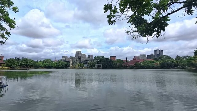 A lake surrounded by modern architectural buildings in a campus environment in Depok, Indonesia