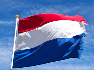 Dutch flag in red, white, and blue waving in the wind