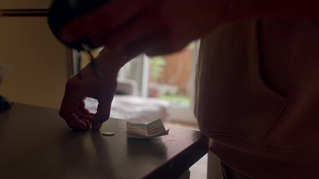 Coins transaction morning, Domestic setting with man exchanging coins calmly during morning, Man places coins on counter and table in peaceful home environment during morning